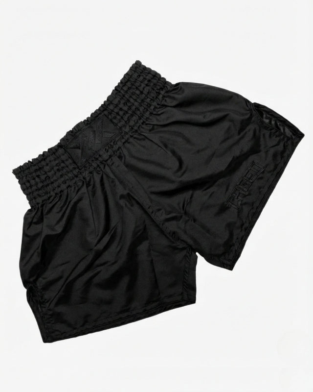 Caged Muay Thai shorts Classic - Sort/Sort flat lay