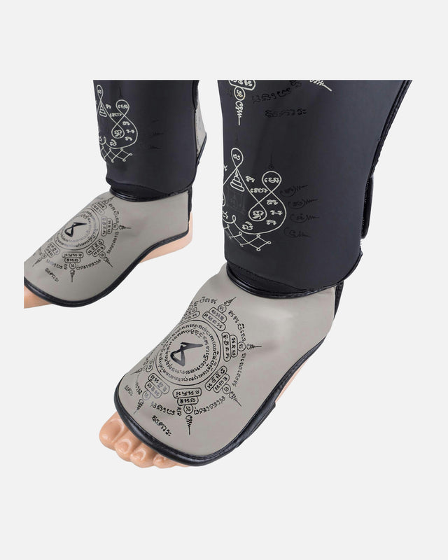 Espinilleras 8 WEAPONS 8 Ways Yant – Negro/Arena